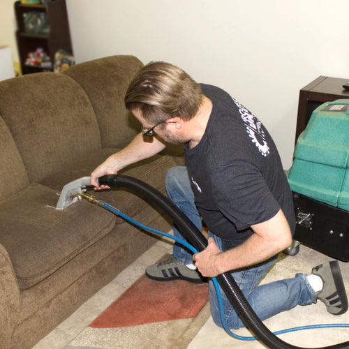 Heated carpet cleaning machine cleaning some upholstery on a couch Thumbnail
